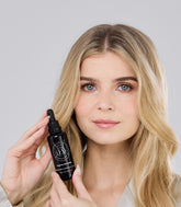 Flacon Hair Growth Serum tenu près du visage