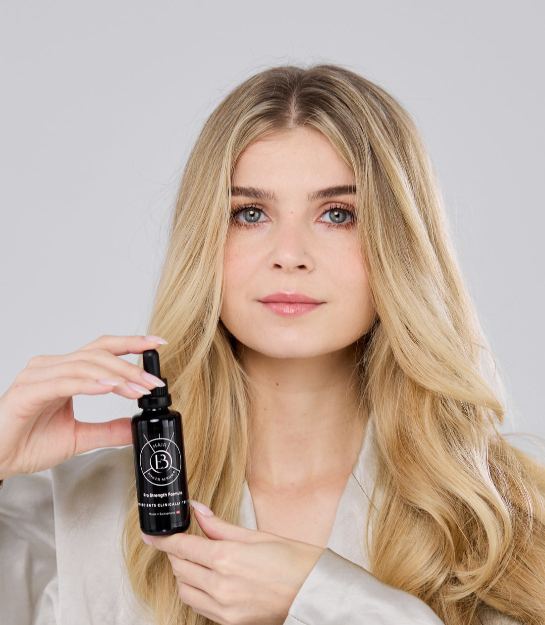 Flacon Hair Power Serum+ tenu près du visage