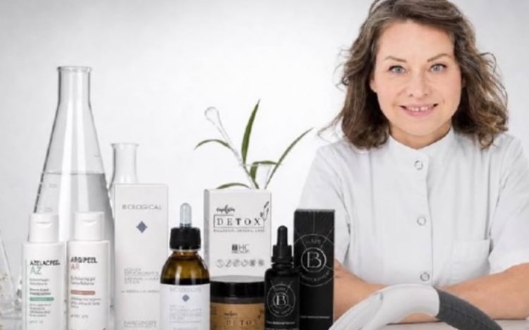 Natallia Jolliet en blouse blanche, à côté de flacons de soins capillaires