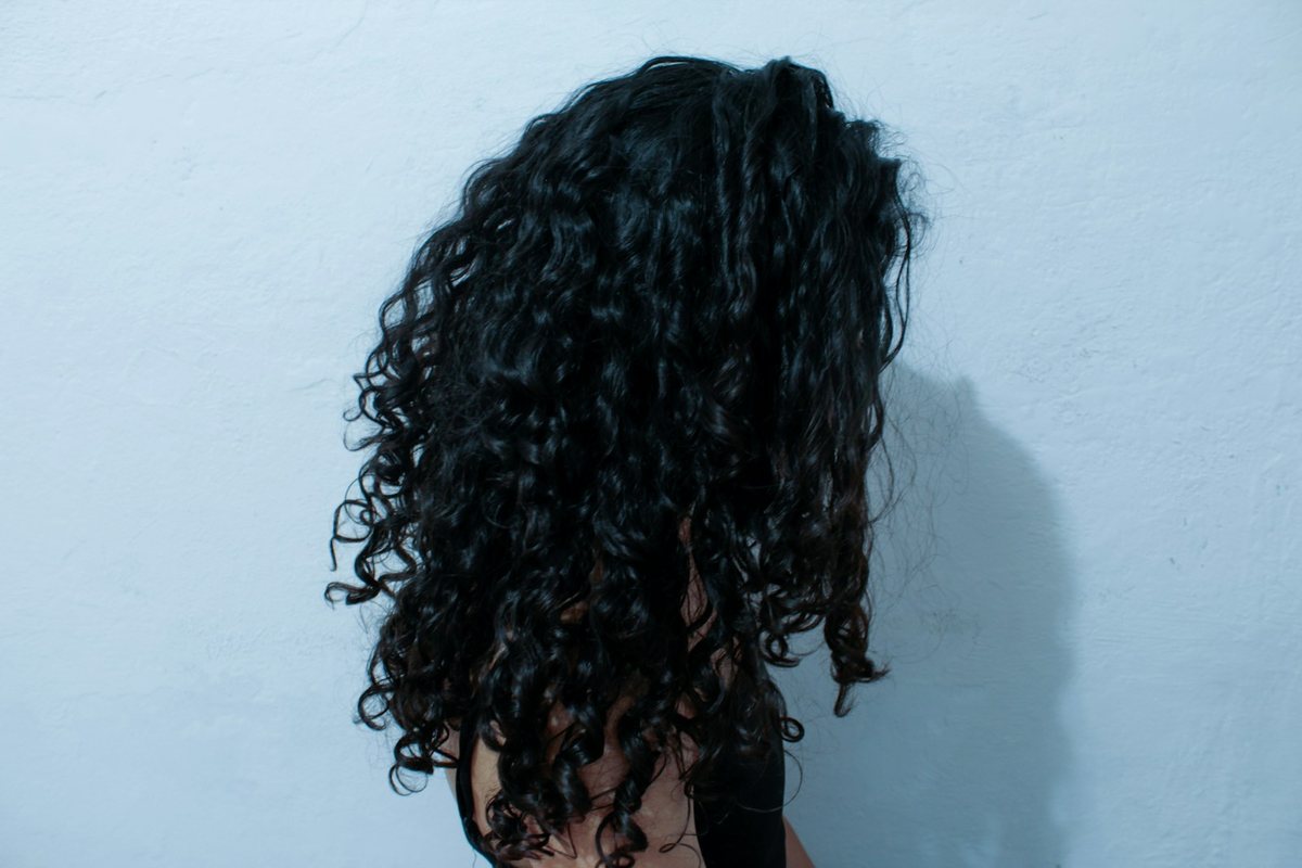 Une femme aux cheveux bouclés, vue de dos